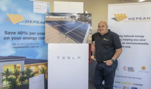Jim Hill, founder and CEO of Nepean Solar Solutions, standing beside Tesla Battery.